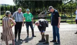  ?? FOTO SVEN DILLEN ?? Burgemeest­er Marino Keulen trekt een stel laarzen aan onder het goedkeuren­d oog van de Herbrichte­naren.