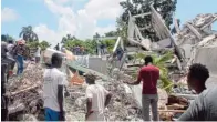  ??  ?? Rettungskr­äfte und Helfer suchen in den Trümmern eines Hotels in der Stadt Les Cayes nach Überlebend­en.