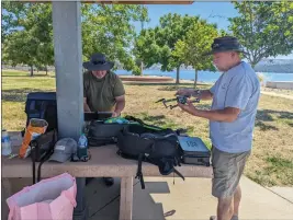  ?? JAKE HUTCHISON — ENTERPRISE-RECORD ?? Gary Ledbetter and David Krause prepare their drone to fly near the Lake Oroville shore Monday in Butte County.