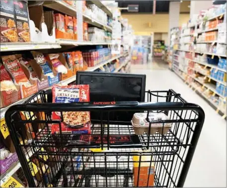  ?? PHOTO BY STEFANI REYNOLDS — AFP) (PHOTO BY STEFANI REYNOLDS/AFP VIA GETTY IMAGES ?? A grocery cart sits in an aisle at a grocery store in Washington, DC, on February 15, 2023. - Retail sales in the United States rebounded in January, government data showed Wednesday, logging the biggest gain since early 2021 as policymake­rs watch for signs that consumer spending is cooling in the longer run.