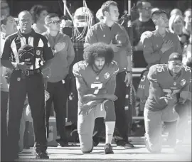  ?? Ezra Shaw Getty Images ?? KNEELING during the national anthem made Colin Kaepernick (7), here joined by Eric Reid, a polarizing figure. His solid play for 49ers last year was overlooked.