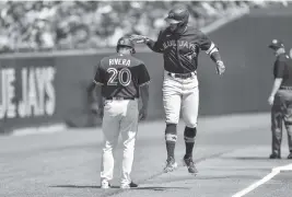  ?? ADRIAN KRAUS AP ?? Toronto Blue Jays’ George Springer, right, taps third base coach Luis Rivera on the head while rounding the bases after hitting a solo home run against Tampa Bay on Saturday.