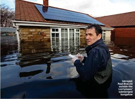  ??  ?? Intrepid: Paul Bracchi outside the Lorrymans’ submerged bungalow