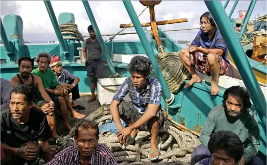  ?? (Dita Alangkara/AP/SIPA) ?? Foreign fishermen gather on their boat during an inspection conducted by Indonesian officials in Benjina, Indonesia, 2015.