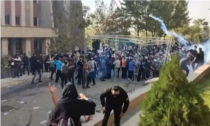  ?? Photograph: UGC/AFP/Getty ?? Protesters try to avoid teargas fired during clashes at a university in Tehran. The whereabout­s of dozens of young people arrested last week remains unknown.