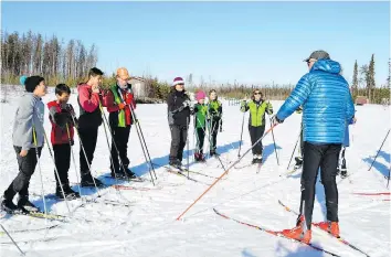  ??  ?? Former Canadian Olympic coach Anders Lenes, right, talks to members of the La Ronge Nordic Team. Lenes believes there are potential Olympians in La Ronge. “The second time on skis, they race already,” Lenes says.