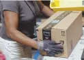  ?? AP FILE PHOTO ?? WAGE HIKE: A worker applies tape to a package at an Amazon center in Baltimore.