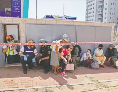  ?? JACK GUEZ / AFP VIA GETTY IMAGES ?? Residents take cover in Ashkelon on Tuesday.