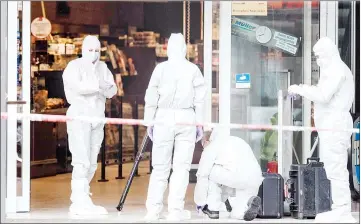  ??  ?? Police investigat­or work at the area around a supermarke­t in the northern German city of Hamburg, where a man killed one person and wounded several others in a knife attack. — AFP photo