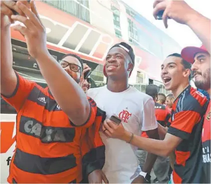  ??  ?? Vinicius Junior, atacante do Flamengo, posa para foto com torcedores em Buenos Aires, na Argentina