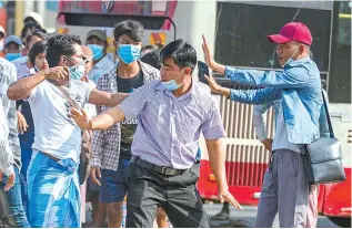  ?? Reuters-Yonhap ?? A military supporter points a sharp object as he confronts pro-democracy protesters during a military support rally in Yangon, Myanmar, Thursday.