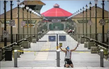  ?? Allen J. Schaben Los Angeles Times Los Angeles Times ?? top left, checks a child’s temperatur­e in Long Beach. Top right, a nurse and patient in the ICU at Providence St. Jude in Fullerton. Above, a woman prays at the closed Huntington Beach Pier.