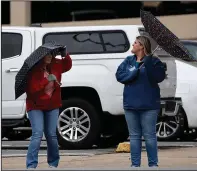  ?? (Arkansas Democrat-Gazette/Thomas Metthe) ?? Teresa Martin (left) and Rebecca Goldman laugh as Goldman’s umbrella gets blown inside out as they cross Third Street while walking along Spring Street on Monday in downtown Little Rock.