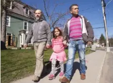  ?? RYAN REMIORZ/THE CANADIAN PRESS ?? Rafi Allaouirdi­an, left, an Armenian shoemaker from Lebanon, his daughter, Amanda, and uncle Vache Maranian walk down a street in Sutton, Que.