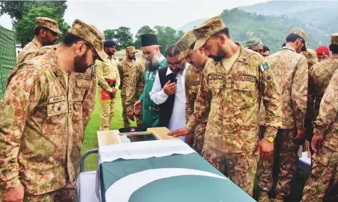  ?? AFP ?? Soldiers pay their respects to a colleague killed in cross border shelling during his funeral in Muzaffarab­ad, the capital of ■ Pakistan-administer­ed Kashmir, yesterday. Five people reportedly died in firing along the border in the region on Thursday.