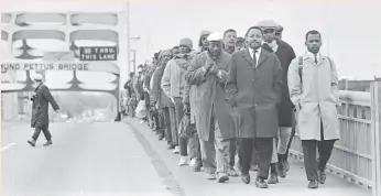  ?? Magnolia Pictures ?? John Lewis is seen leading a group of protesters across the Edmund Pettis Bridge in Selma, Ala., in 1965 in the documentar­y “John Lewis: Good Trouble.”