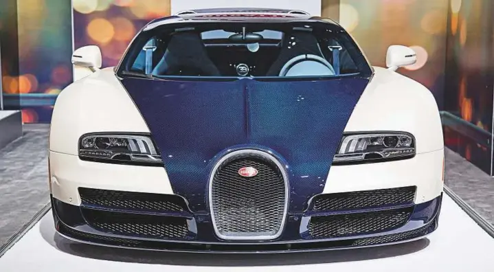  ?? Bloomberg ?? The Bugatti Veyron at the recent New York Internatio­nal Auto Show. The other facet of cultivatin­g the modern luxury buyer is fostering a sense of ultra exclusivit­y, both on the automaker level and on the dealer level. Production numbers must remain...