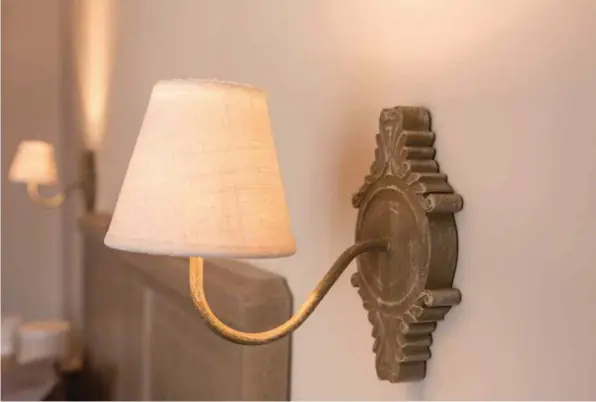  ??  ?? Dans la chambre à coucher, la décoration reste dans un style charme, avec des harmonies de beiges et de vieux rose qui créent une atmosphère très douce. Le mobilier de famille a là aussi été décapé et repeint dans des tons beiges.