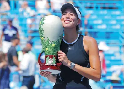  ?? AARON DOSTER / USA TODAY SPORTS ?? Spain’s Garbine Muguruza embraces the Rookwood Cup after defeating Simona Halep of Romania in Sunday’s final of the Western and Southern Open in Mason, Ohio.