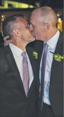  ?? Picture: AP ?? West Australian upper house MP Stephen Dawson, right, gives his husband Dennis Liddelow a kiss after they married in front of Parliament House yesterday