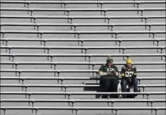  ?? MIKE ROEMER ?? Two fans are shown in the stands before an NFL football game between the Green Bay Packers and the Baltimore Ravens Sunday, Nov. 19, 2017, at Lambeau Field in Green Bay, Wis. Businesses near NFL stadiums have been hit hard due to pandemic-imposed attendance restrictio­ns this season.