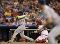  ?? MATT SLOCUM - THE ASSOCIATED PRESS ?? File-This Aug. 11, 2017, file photo shows New York Mets’ Yoenis Cespedes, left, following through after hitting a three-run home run as Philadelph­ia Phillies catcher Jorge Alfaro, center, and third base coach Glenn Sherlock look on during the third inning of a baseball game, in Philadelph­ia.