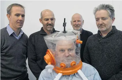  ?? PHOTO: GERARD O’BRIEN ?? Respiratio­n product aspiration­s . . . Mark Seaton, Chris Hopkins, William Early and Andrew Wallace look on as Richard Aimers tries on a ventilator hood made in Dunedin.