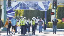  ?? JEFF GRITCHEN — STAFF PHOTOGRAPH­ER ?? Visitors and employees exit the Disneyland Resort at the Harbor Boulevard entrance in Anaheim on March 5.