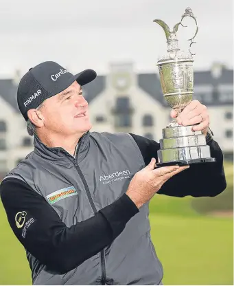  ?? Picture: SNS Group. ?? Paul Lawrie admires the Claret Jug he lifted in 1999 at Carnoustie as he returned to the Angus links to mark the opening of ticket sales for the 147th Championsh­ip next July. See page 48.