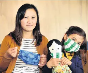  ?? PHOTO: CHRISTINE O'CONNOR ?? Mask makers . . . Dr Ling Chan, a pathology doctor in Dunedin, and her daughter, Isla Ansell (6), holding her doll also called Isla, display some of the cloth masks made in their home office.