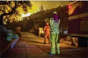  ?? DAVID MCNEW / GETTY IMAGES ?? Firefighte­rs look on as the Thomas Fire approaches homes Tuesday in Montecito, Calif. It has burned over 900 structures since Dec. 4.