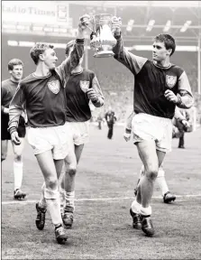  ?? ?? John Sissons, left, and Geoff Hurst lifting the FA Cup at Wembley Stadium in 1964