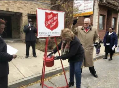  ?? BY NICHOLAS BUONANNO NBUONANNO@DIGITALFIR­STMEDIA.COM ?? Catherine Murray of Blanchard Industrial Supplies donates to the Red Kettle campaign in Troy on Thursday as her husband, Larry Murray, rings the bell.