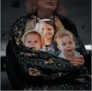  ?? ODED BALILTY/ASSOCIATED PRESS ?? A woman holds a mask depicting the faces of Shiri Bibas and her sons Kfir and Ariel, Israelis who are being held hostage in the Gaza Strip by the Hamas militant group, during a protest demanding the release of the hostages from Hamas captivity, in Tel Aviv, Israel, Wednesday, Feb. 21, 2024. Relatives of hostages still being held by Hamas and other militant groups have endured a nightmare. Nearly five months into the war that began with Hamas’ deadly Oct. 7 attack on Israel, the hostages relatives hold on to hope that they will be freed but are growing increasing­ly desperate for a resolution.