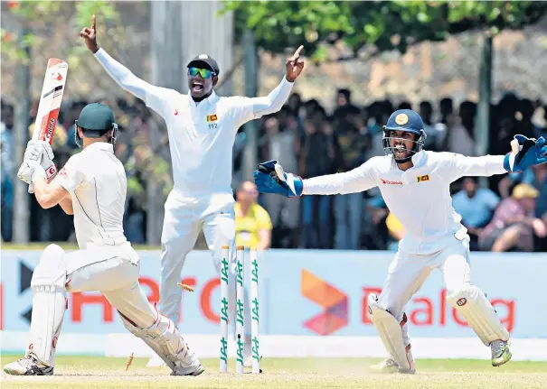  ??  ?? In control: Sri Lankans Angelo Mathews (centre) and Dinesh Chandimal celebrate the dismissal of Australia’s Adam Voges on the third day of the second Test in 2016