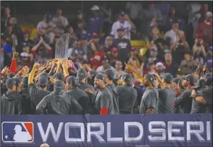  ?? The Associated Press ?? COMMISSION­ER’S TROPHY: The Boston Red Sox hold the championsh­ip trophy after winning Game 5 of the World Series against the Dodgers in Los Angeles.