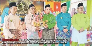  ??  ?? TANDA INGATAN: YDP PIBG, guru besar, ketua kampung dan penyelia KAFA memberi bunga telur dan pulut kuning kepada Awang Zainuri.