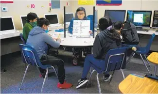  ?? NELVIN C. CEPEDA U-T ?? On Dec. 10, Selena Hernandez, a bilingual instructio­nal aide at Oak Crest Middle School in Encinitas, shares a lesson plan with some of her seventh- and eighth-grade students.