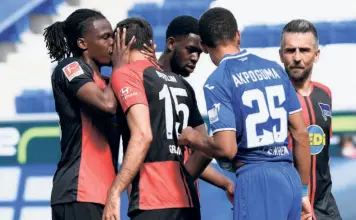  ?? AFP ?? Too close for comfort? Hertha Berlin’s Dedryck Boyata could not contain his emotions and kissed teammate Marko Grujic on the cheek, breaking the new guidelines for close contact during celebratio­ns.