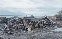  ?? ANDREW VAUGHAN THE CANADIAN PRESS ?? Debris from a burnt out fish plant is scattered along the shore in Middle West Pubnico, N.S., the latest battlegrou­nd in an escalating crisis over Indigenous fishing rights.