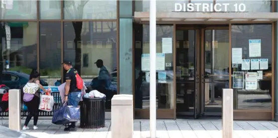  ?? OWEN ZILIAK/SUN-TIMES FILE ?? Migrants gather their belongings outside the Ogden district police station last month.