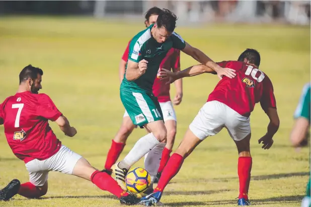  ??  ?? TOUGH TRIAL: Cairns FC player Crios O'Hare tussles with eager North Queensland United defenders in the trial match at Brolga Park on Saturday.