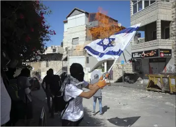  ?? MAHMOUD ILLEAN — THE ASSOCIATED PRESS FILE ?? Palestinia­ns burn an Israeli flag during clashes with police in east Jerusalem’s neighborho­od of Issawiya.