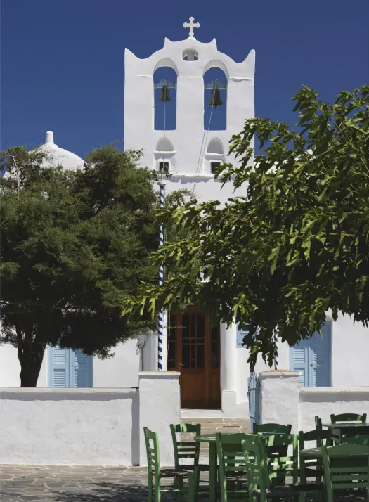  ??  ?? Wooden chairs from a nearby ouzeri outside the Orthodox Church Agios Konstantin­os in Artemonas, Sifnos