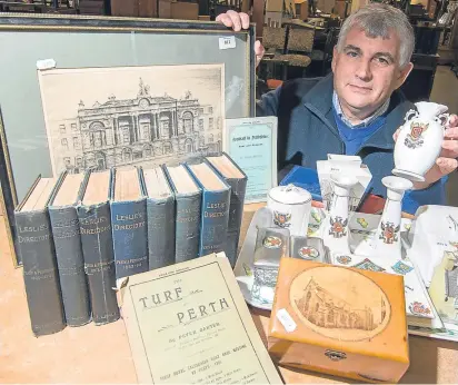  ??  ?? Auctioneer Iain Smith with some of the items collected by former councillor and Perth historian Stanley Keay.