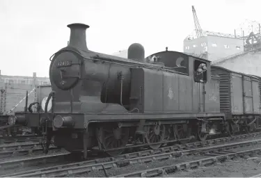  ?? L R Freeman ?? Railway activity at Deptford Wharf was much reduced at weekends but there still one round trip booked over the branch on Saturdays. This left New Cross Gate at 1.25pm and returned from the Wharf at 3.10pm. The rail tour was booked away at 2.45pm and LB&SCR Billinton ‘E6’ 0-6-2T No 32415 is captured marshallin­g a train in the sidings at Deptford Wharf before following the tour off the branch after its duties were concluded here.