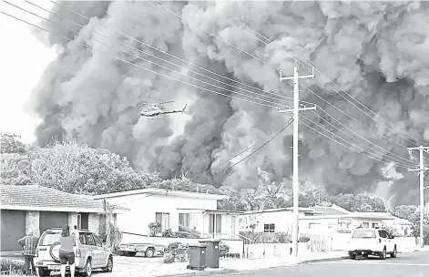  ?? — AFP photo ?? A handout picture received from Kelly-ann Oosterbee shows flames from an out of control bushfire seen from a nearby residentia­l area in Harrington, some 335 kilometres northeast of Sydney.