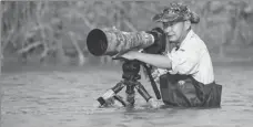  ?? PROVIDED TO CHINA DAILY ?? Li Dongming takes photos of shorebirds on the intertidal mudflats at Tiaozini.