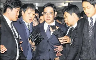  ?? CHOI JAE-KOO / YONHAP ?? Samsung Vice Chairman Lee Jae-yong (center), accused of participat­ing in a corruption scandal, leaves after attending a court hearing Thursday in Seoul, South Korea. His arrest raises questions about the fate of Samsung, whose electronic­s arm accounts...