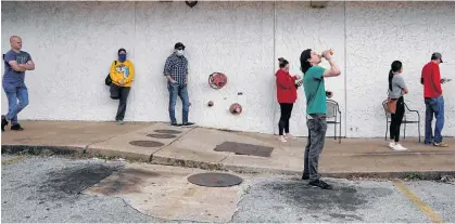  ?? REUTERS ?? People who lost their jobs wait in line to file for unemployme­nt following an outbreak of the coronaviru­s disease, at an Arkansas Workforce Center in Fayettevil­le, Ark. on April 6.